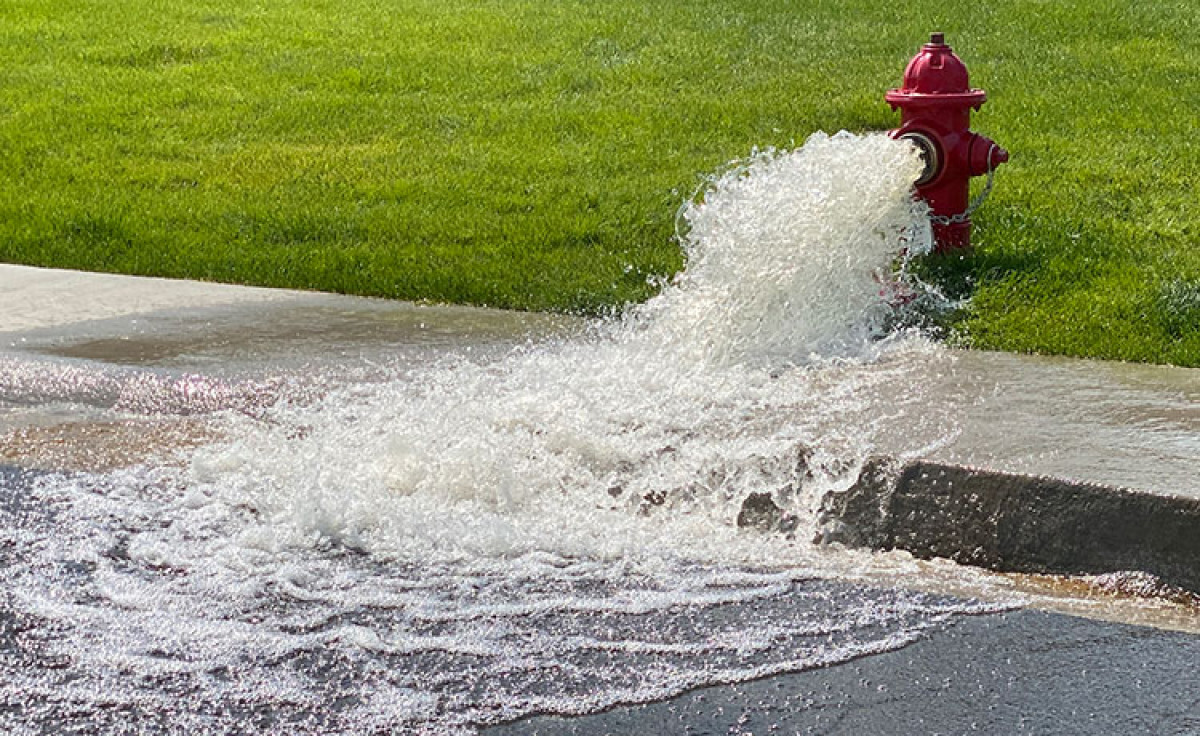 Rinçage unidirectionnel d’un réseau d’aqueduc : eau s’écoulant d’une borne-fontaine vers la rue
